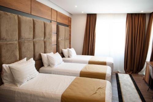 格勒姆Hilal Palace - Halal的酒店客房设有两张床和窗户。