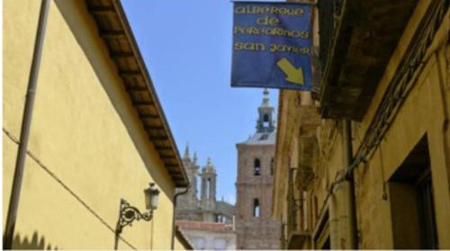 阿斯托加Albergue San Javier - Solo para peregrinos的建筑的一边有蓝色的标志,有塔