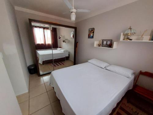 隆德里纳Apartamento próx ao centro Londrina的卧室配有白色的床和镜子