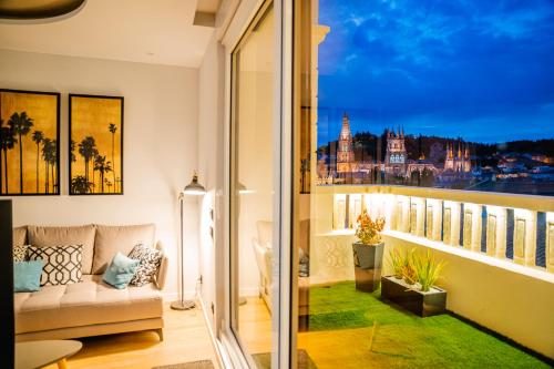 布尔戈斯Catedral - Apartamentos Burgos Deluxe的阳台配有沙发,享有城市美景