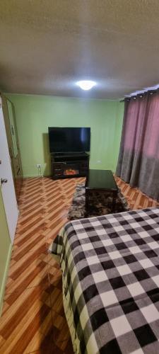 圣地亚哥Casa Enea Pudahuel的客厅配有床和平面电视