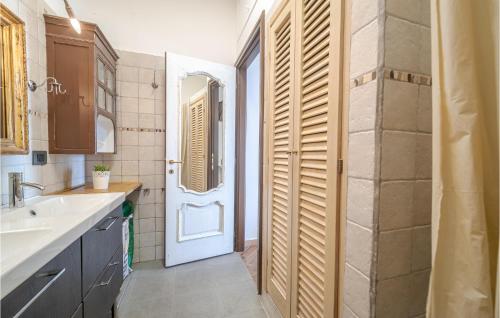 卡莫利2 Bedroom Cozy Home In Camogli的一间带水槽的浴室和一个带镜子的门