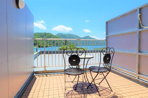 日光旅笼Nagomi温泉酒店(Hatago Nagomi)的船上的阳台配有两把椅子和一张桌子