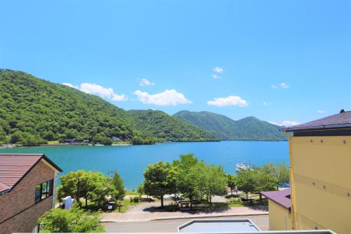 日光旅笼Nagomi温泉酒店(Hatago Nagomi)的享有以山脉为背景的湖泊美景