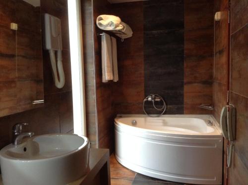 沃洛斯帕克酒店的浴室配有白色浴缸和水槽
