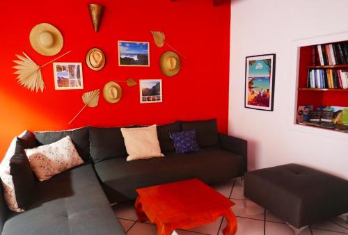 圣皮埃尔Les Baroudeurs Hostel的带沙发和红色墙壁的客厅