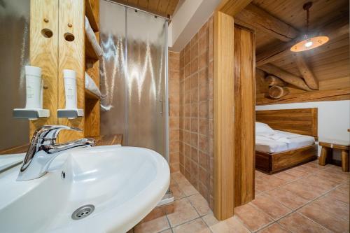 伦达瓦Hiša vina Cuk的一间带水槽的浴室和一张位于客房内的床