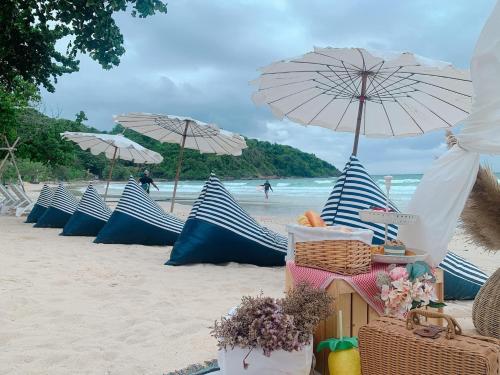 沙美岛Kerala Coco Resort的海滩上一排蓝白遮阳伞