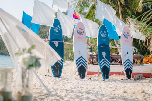 沙美岛Kerala Coco Resort的海滩上排成一排冲浪板