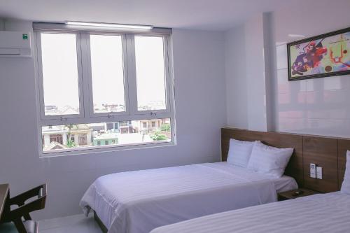 洞海Vagibi Hotel的酒店客房带两张床和两个窗户