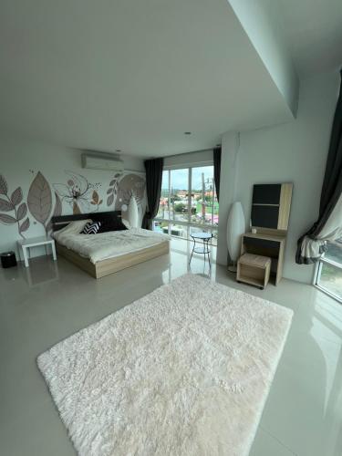 奈汉海滩The CHU cafe / guesthouse的一间白色卧室,配有床和地毯