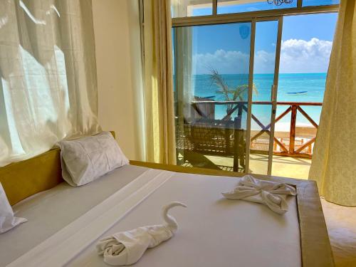 江比阿Equalia Rose hotel的一间卧室设有一张床,享有海景