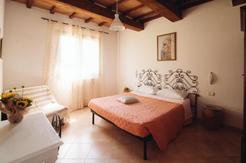 Bagno RoselleAgriturismo Le Giare的一间卧室设有一张床和一个窗口