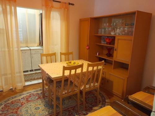 泽莱尼卡Zelenica Apartment的一间带桌椅和窗户的用餐室