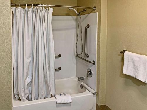 萨克拉门托Rodeway Inn Sacramento-University Area的浴室配有淋浴帘和浴缸。