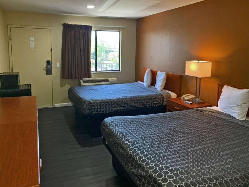 萨克拉门托Rodeway Inn Sacramento-University Area的酒店客房设有两张床和窗户。