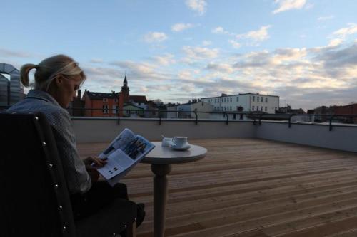 科希切日纳博勒沃库斯耶勒酒店的坐在屋顶上看报纸的女人
