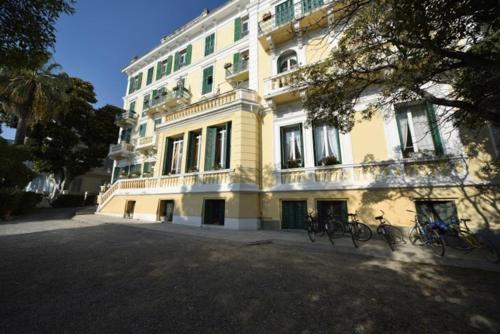 欧斯佩达蒂佩蒂特皇家酒店的一座大型黄色建筑,前面停放着自行车