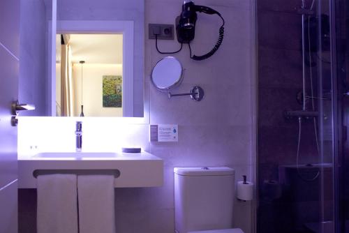 马德里Woohoo Rooms Boutique Sol的一间带水槽、卫生间和镜子的浴室