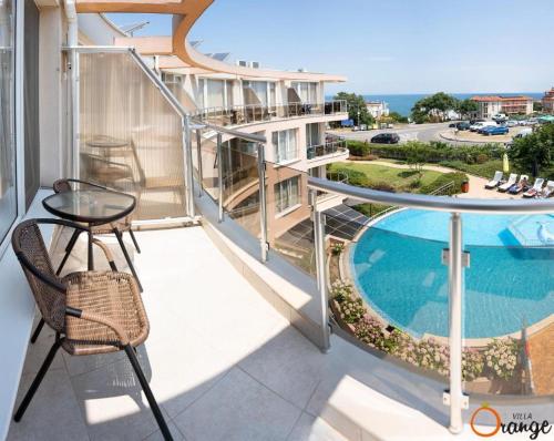 索佐波尔奥林奇别墅公寓式酒店的一个带桌子和游泳池的阳台