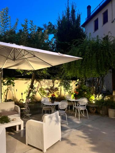代森扎诺-德尔加达Residenza Elisa的一个带桌椅和遮阳伞的庭院