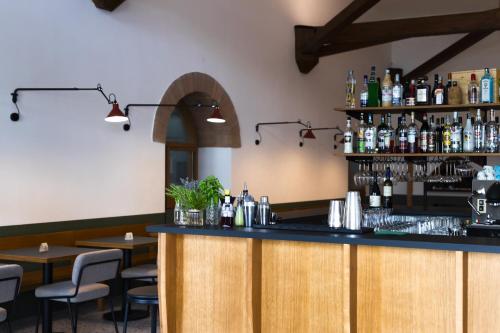 卡斯泰尔梅扎诺Hotel Dolomiti的餐厅内的酒吧配有桌椅