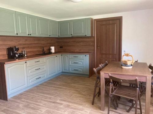 Petreştii de JosCasa Cheilor的厨房配有绿色橱柜和桌椅