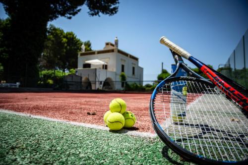 普尔萨诺Antica Casina B&B di Charme的网球场上三个网球,球拍