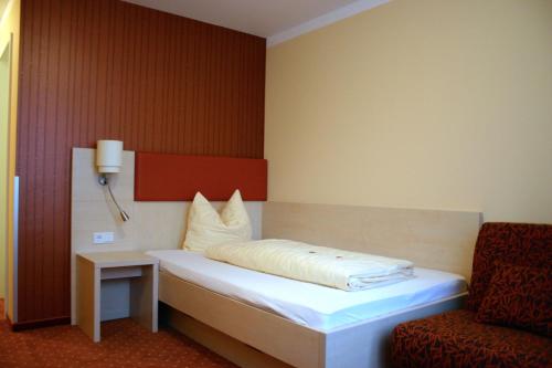 纽伦堡佩特侦花园酒店的一张床位,房间配有椅子和床筒