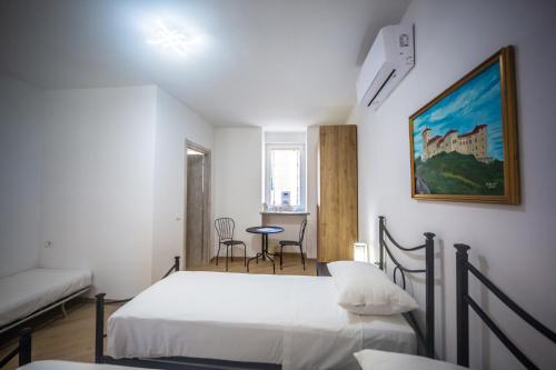 里诺迪莱吉诺Around Lago Maggiore rooms的一间卧室配有两张床和一张桌子及椅子