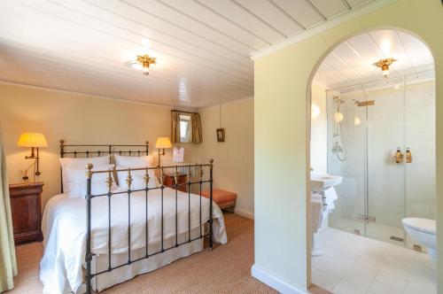 斯莱克－埃韦克De Heerlijkheid Loenen Bed en Breakfast的一间卧室设有一张床和一个步入式淋浴间。