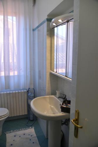 洛雷托My House的一间带水槽和卫生间的浴室以及窗户。