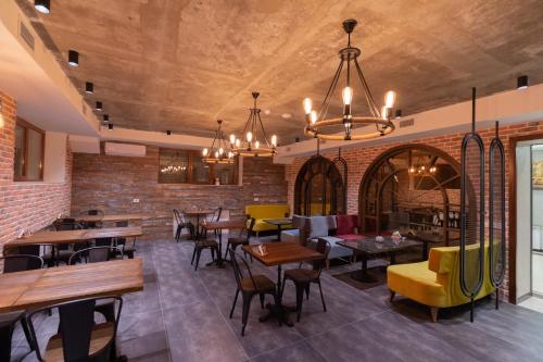 巴库Merida Hotel Baku的一间带桌椅的餐厅以及砖墙