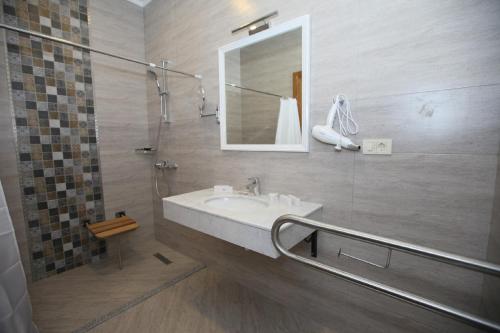 巴库Auroom Hotel的浴室配有盥洗盆和带镜子的淋浴