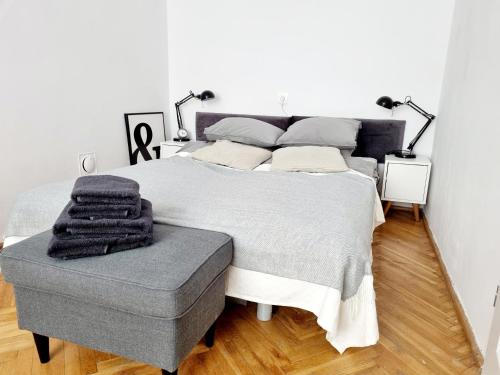 华沙Apartament Miodowa Warszawa的一间卧室配有一张大床和灰色的搁脚凳