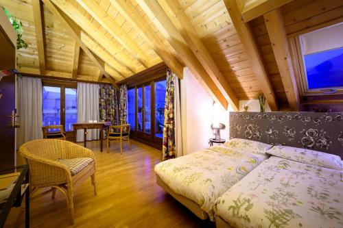 蒂拉诺Bernina Express Eco Rooms&Breakfast的卧室配有一张床和一张桌子及椅子
