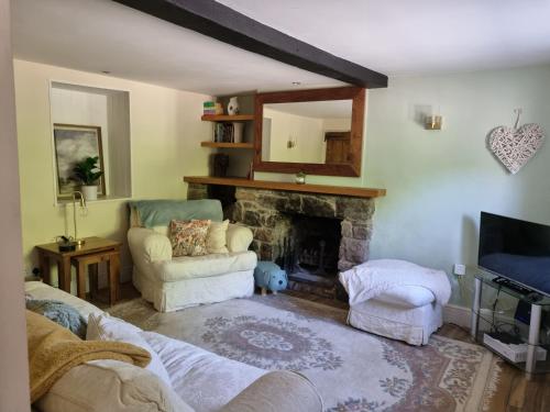 LangfordBay Tree Cottage的带沙发和壁炉的客厅