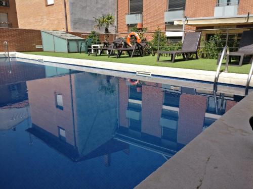 阿尔卡拉德荷那利斯胡安一世公寓酒店的坐在游泳池长凳上的人