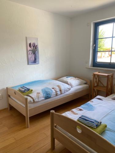 PutgartenHofgut Wollin GmbH的一间卧室设有两张床和窗户。