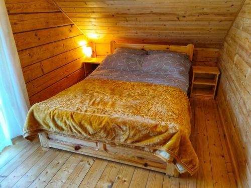奇胡夫Chatki U Hanusi的木制客房内的一间卧室,配有一张床
