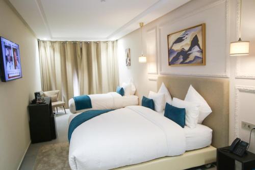 达赫拉Dakhla Boarding Hotel & Restaurant的卧室配有带蓝色枕头的大型白色床