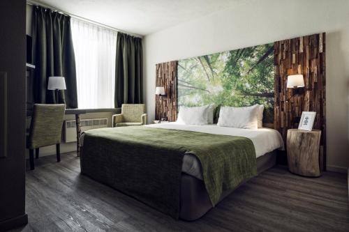 亨克Hotel Zuid的酒店客房设有一张大床和一张书桌。