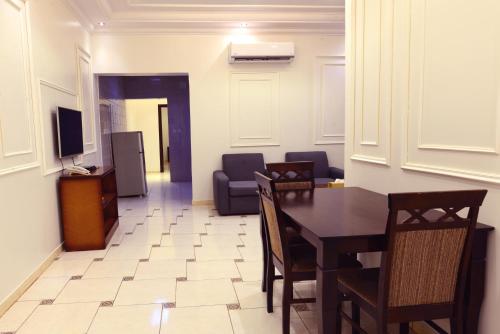 利雅德منازل المرجان للوحدات السكنية المفروشة Manzel Al Murjan Hotel Apartments的一间带桌椅和电视的用餐室