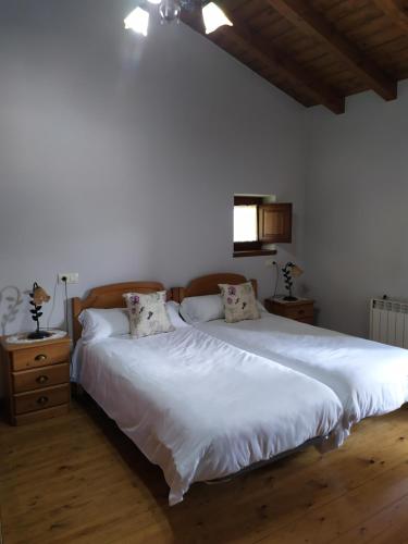 PerllecesCasa Adela El Tuxu的卧室配有一张带两个枕头的大白色床
