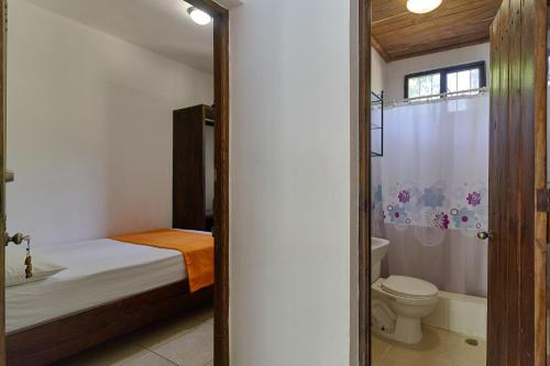 哈拉瓦科阿Villa Bayacanes con piscinas privadas的一间卧室设有一张床、一个卫生间和淋浴。