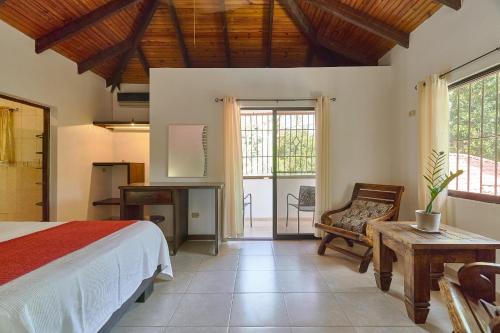 哈拉瓦科阿Villa Bayacanes con piscinas privadas的一间卧室配有一张床、一张桌子和一把椅子
