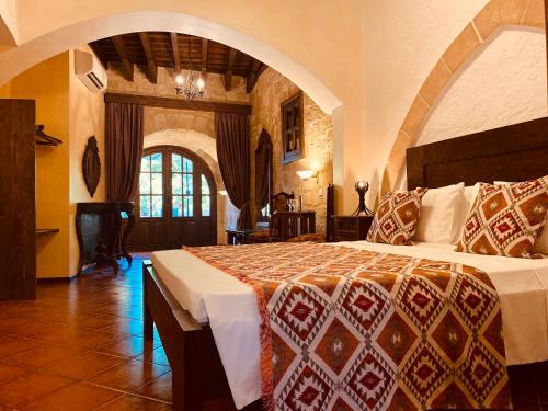 罗德镇斯尼克里斯历史精品酒店的一间卧室,卧室内配有一张大床
