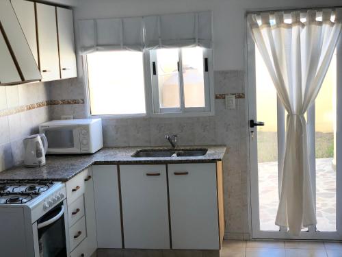 普拉亚欧尼恩ZR Playa Union的厨房配有水槽、微波炉和窗户