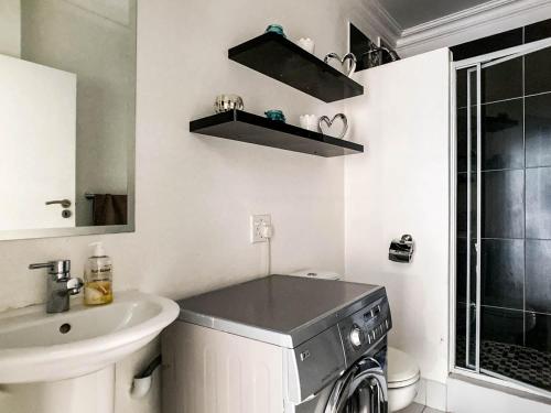 约翰内斯堡Splice Apartments的一间带洗衣机和水槽的浴室