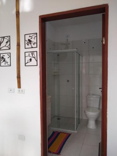 乌巴图巴La Casa Rozada Prumirim的一间带玻璃淋浴和卫生间的浴室